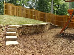 a wooden swing set in the middle of a yard with steps leading up to it