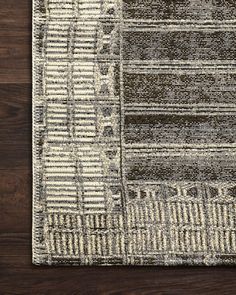 an area rug on a wooden floor with dark brown and white colors, including stripes