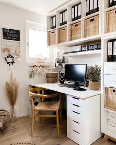 a desk with a computer on top of it in front of some baskets and other items