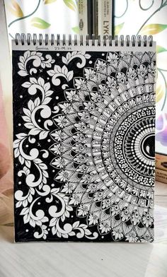 a black and white spiral notebook sitting on top of a table