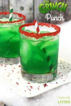 two glasses filled with green liquid and red sprinkles sitting on top of a white plate