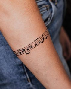 a person with a musical note tattoo on their arm