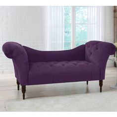 a purple couch sitting on top of a white rug