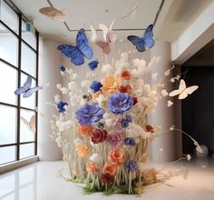 an arrangement of flowers and butterflies in a room