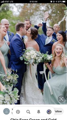 a group of people standing next to each other with their arms in the air and laughing