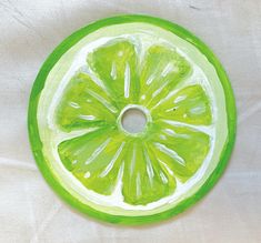 a lime slice is shown in the middle of a painting on white paper with green trim