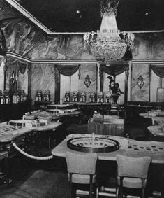 an old fashioned dining room with chandeliers and tables