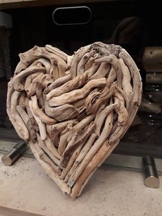 a heart shaped sculpture made out of driftwood