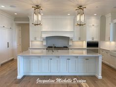 a large kitchen with white cabinets and an island