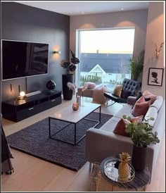 a living room filled with furniture and a flat screen tv mounted to the side of a wall