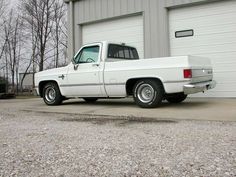 a white truck parked in front of a garage