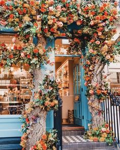 an entrance to a store decorated with flowers