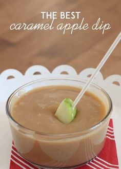 the best caramel apple dip is in a glass bowl on a red and white napkin