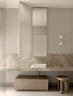 a modern bathroom with two stools and mirrors