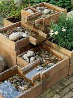 several wooden boxes filled with rocks and plants