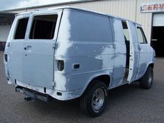 an old van is parked in front of a building that has been painted blue and white