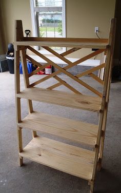 a wooden shelf sitting on top of a carpeted floor in front of a window