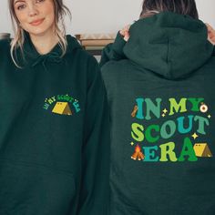 a woman wearing a green hoodie with the words in my scout written on it