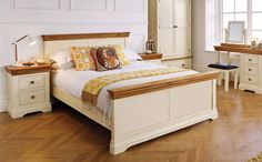 a bedroom with white furniture and wooden floors