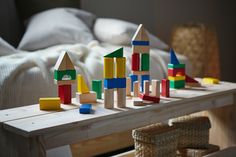 wooden blocks are arranged on a table in front of a bed