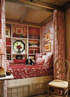 a dog laying on top of a bed in a room with pink walls and curtains