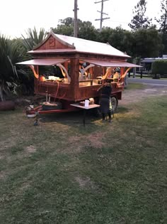 a man sitting at a picnic table in front of a food truck on the grass