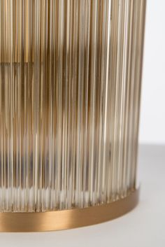 a close up view of a metal object on a white surface with gold trimmings