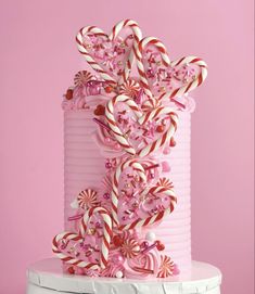 a pink cake decorated with candy canes and candies