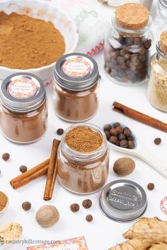 several jars filled with different types of spices and nuts on a table next to cookies