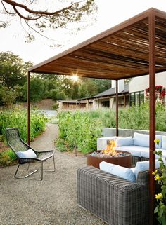 an outdoor living area with couches and fire pit