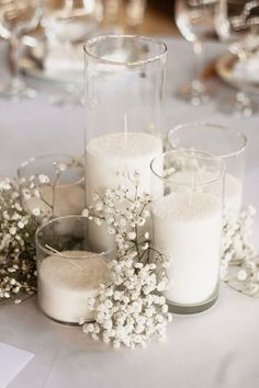 some white candles are sitting on a table