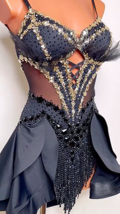 a mannequin wearing a black and gold dress with sequins on it