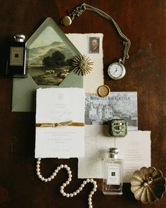 an assortment of items on a table including a note, watch and other things to include