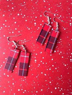 two red and black plaid earrings on a red background