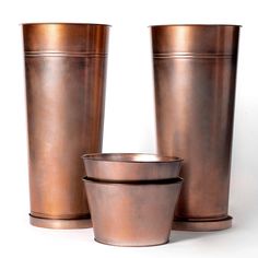 three copper colored metal cups sitting next to each other