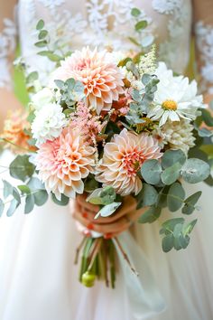 a bride holding a bouquet of flowers in her hands