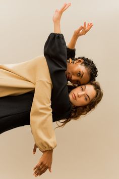 two women are posing for the camera with their hands in the air