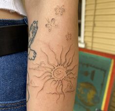 a woman's arm with a tattoo on it that has a sun and butterflies