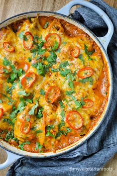 a casserole with tomatoes, cheese and parsley in a blue skillet