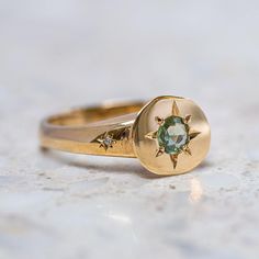 A green sapphire is set into our Sun Ring with two tiny star set G/VS diamonds in the shoulders. Sapphire measures 4.5mm. Total diamond weight 0.01ct. Top of ring measures 12.5 x 10.5mm. Band width 3mm at back. Pictured with a high shine finish. For a matte finish, please leave a note at checkout. Sun Ring, Golden Ring, Tiny Star, Vs Diamond, Green Sapphire, Jewelry Inspo, Hair Colour, Perfectly Imperfect, Green Stone