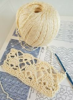 yarn and crochet are laying on top of paper