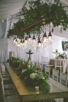 a long wooden table topped with lots of greenery