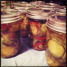 several jars filled with pickles sitting on top of a table