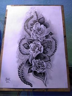 a drawing of roses and pearls on a piece of paper with beads around it,