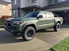 a green truck parked in front of a house