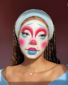 This whimsical clown makeup is all about bright colors and exaggerated features, perfect for a fun Halloween makeup look. The vibrant pinks and blues create a playful yet slightly eerie vibe. The large, expressive eyes and heart-shaped detail add a touch of cuteness to this otherwise bold look.   Photo credit by: @lanayanette Full Face Colorful Makeup, Pink And Green Clown Makeup, Artistic Halloween Makeup, Pink And Blue Clown Makeup, Clown Heart Makeup, Clown Drag Makeup, Classic Clown Makeup, Blue Clown Makeup, Heart Clown Makeup