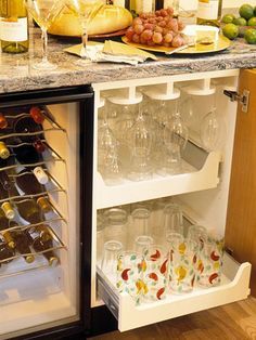 an open refrigerator filled with lots of bottles and glasses