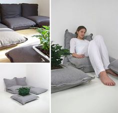 a woman sitting on the floor next to pillows and plants