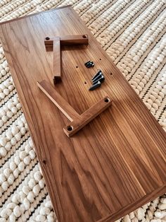 a wooden table that has some scissors on it and is laying on top of a rug