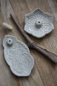 two white ceramic dishes sitting on top of a wooden table next to a pair of scissors